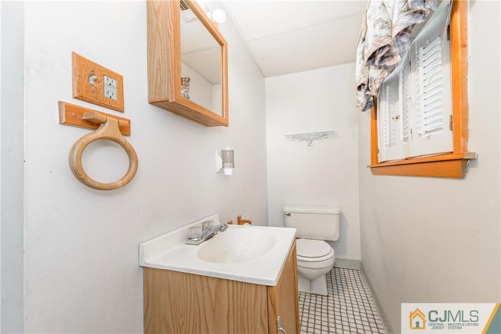 111 Greymoor Road Howell, NJ 07731 - Photo 19 of 25 a bathroom with a sink a toilet and a mirror