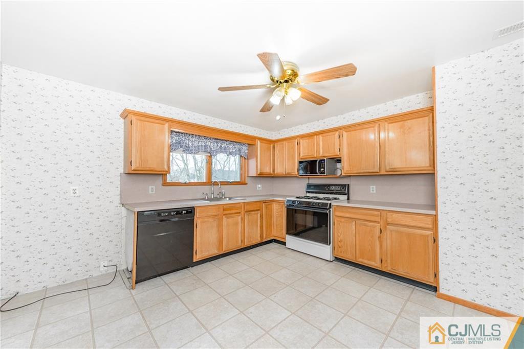 111 Greymoor Road Howell, NJ 07731 - Photo 5 of 25 a large kitchen with granite countertop a stove top oven sink and cabinets