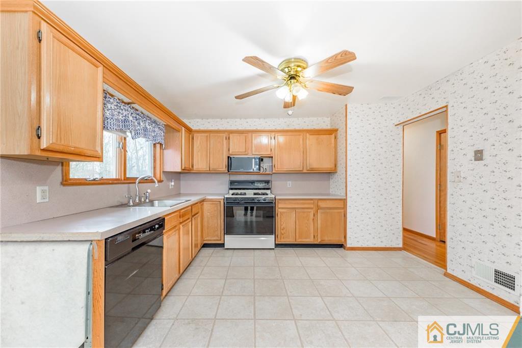 111 Greymoor Road Howell, NJ 07731 - Photo 6 of 25 a large kitchen with a stove a sink dishwasher and a refrigerator