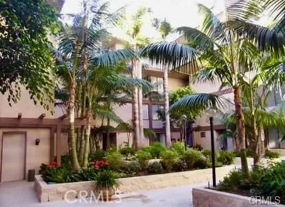 a front view of multi story residential apartment building with yard and sign board