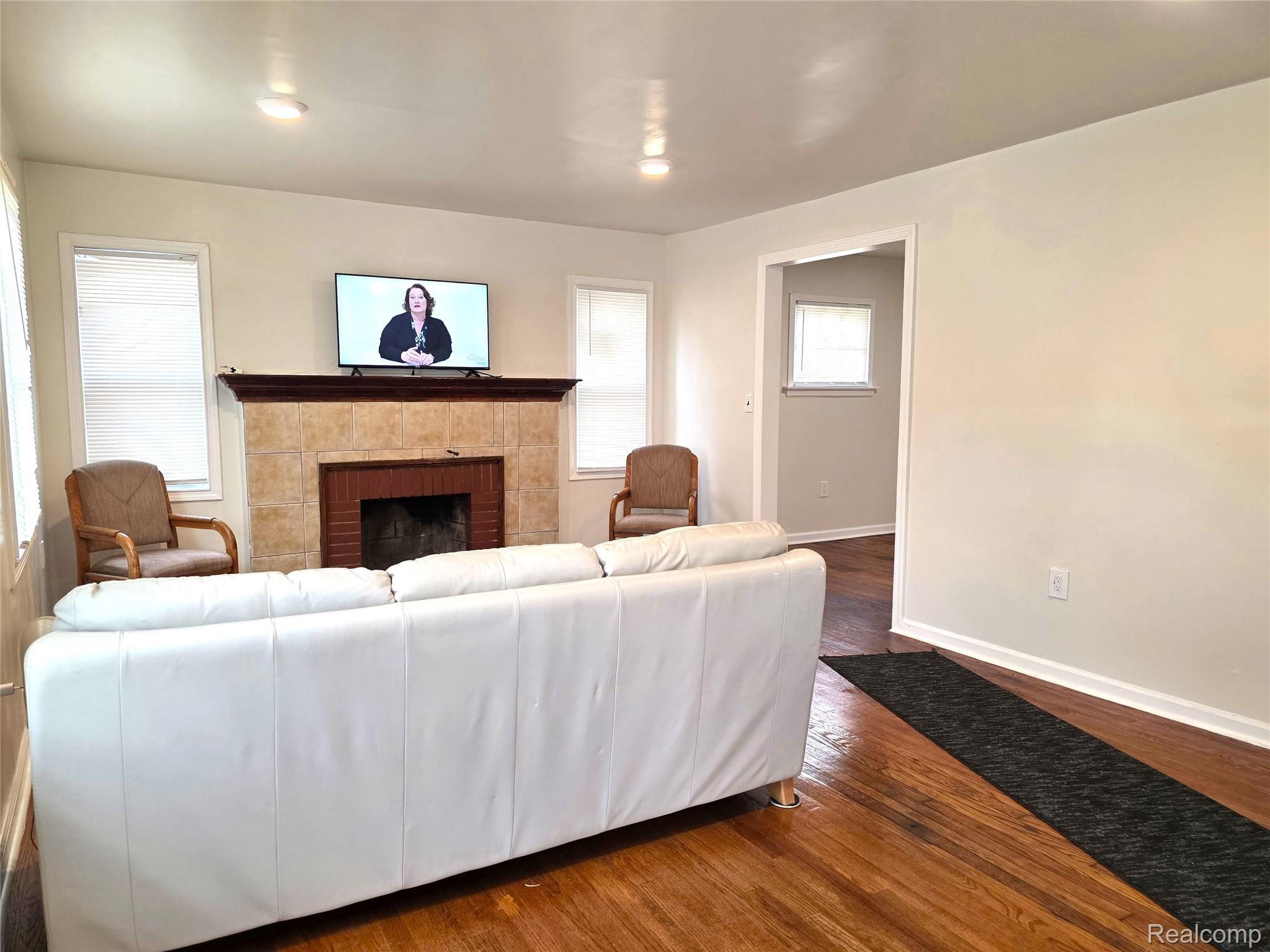 16814 Strathmoor Street Detroit, MI 48235 - Photo 3 of 31 Warm wood-finish flooring, recessed lighting, and a tiled fireplace with a dark wood mantel