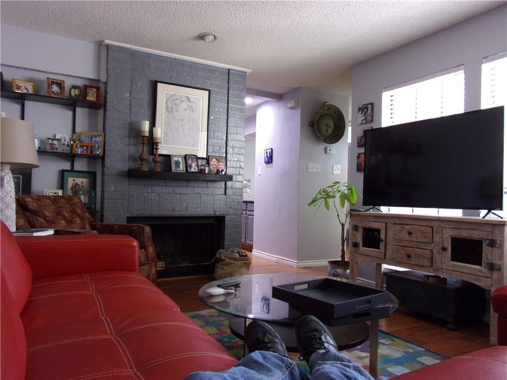 18240 Midway Road, Unit 105 Dallas, TX 75287 - Photo 9 of 37 a living room with furniture a flat screen tv and a fireplace