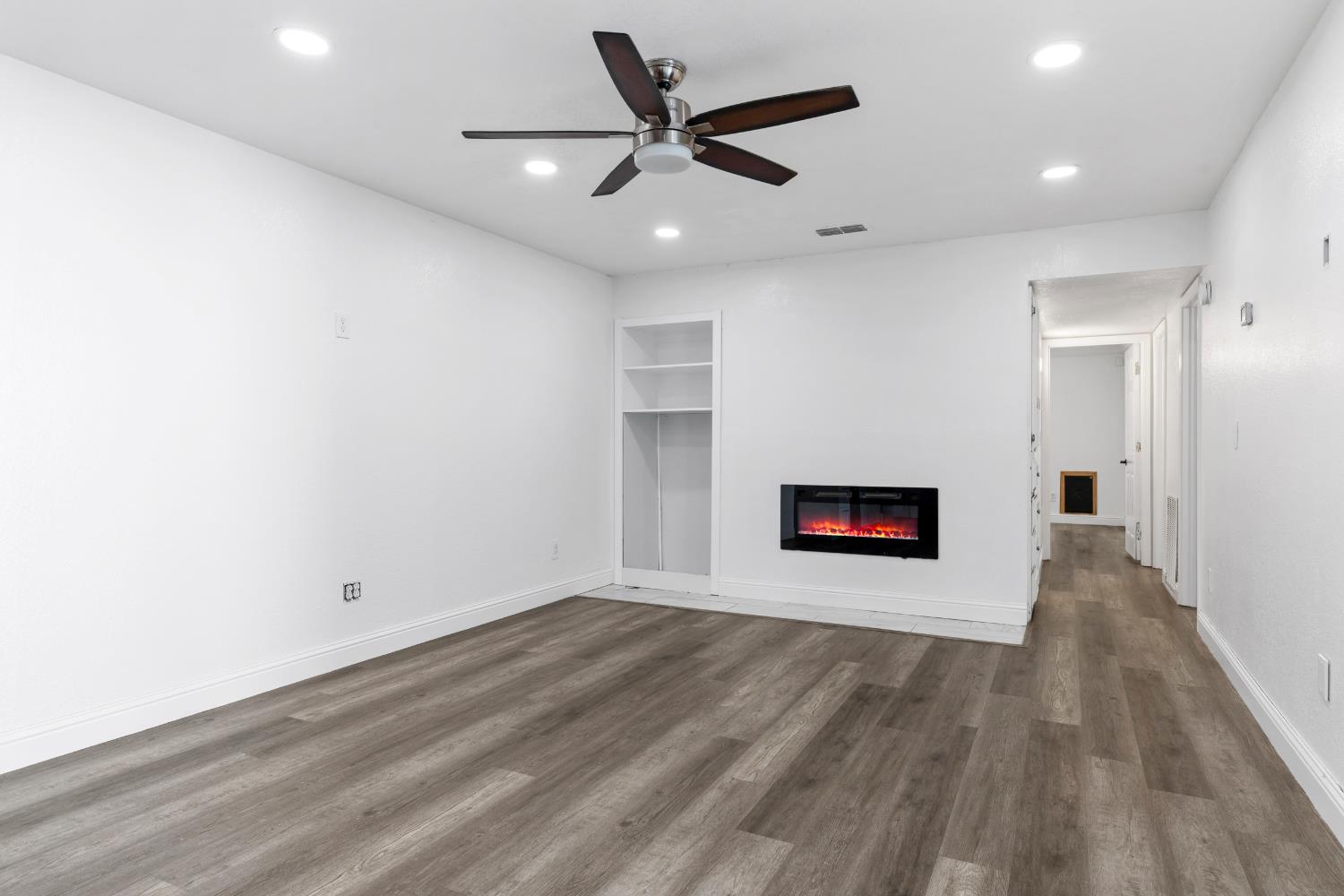 4005 Goldust Drive Modesto, CA 95355 - Photo 15 of 36 a view of an empty room with wooden floor and a ceiling fan