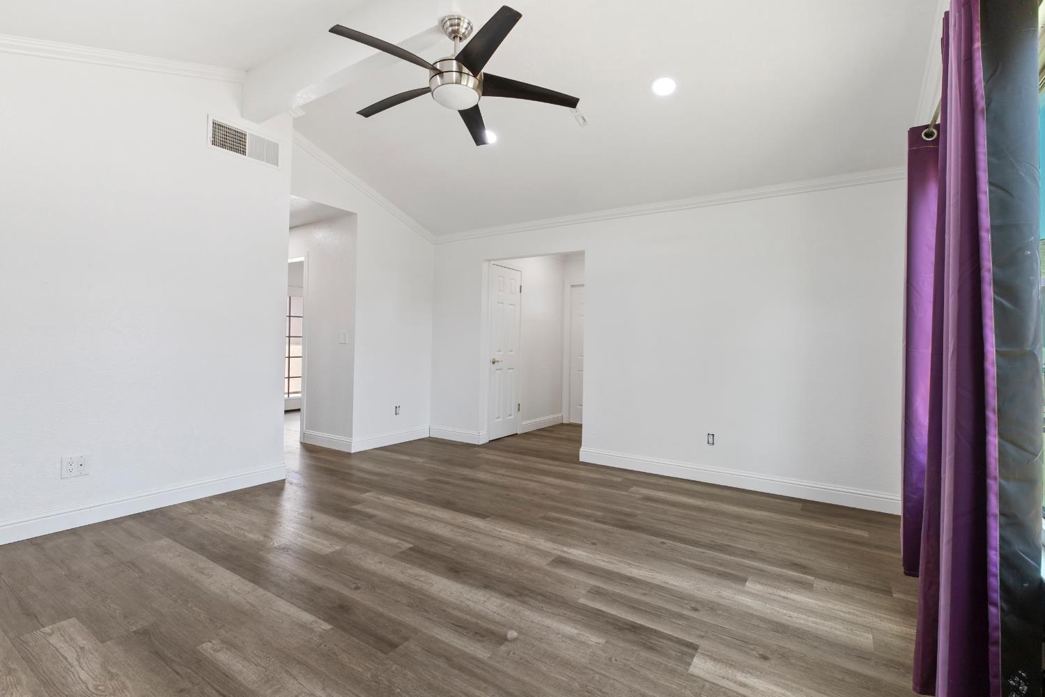 4005 Goldust Drive Modesto, CA 95355 - Photo 5 of 36 an empty room with wooden floor and a ceiling fan