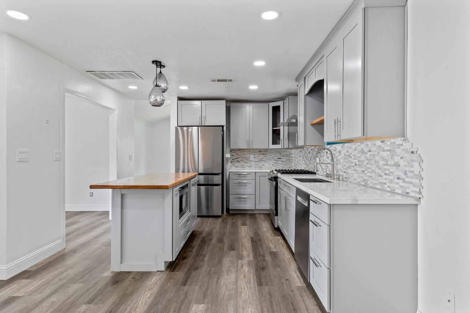 4005 Goldust Drive Modesto, CA 95355 - Photo 7 of 36 a kitchen with stainless steel appliances granite countertop a sink stove and refrigerator