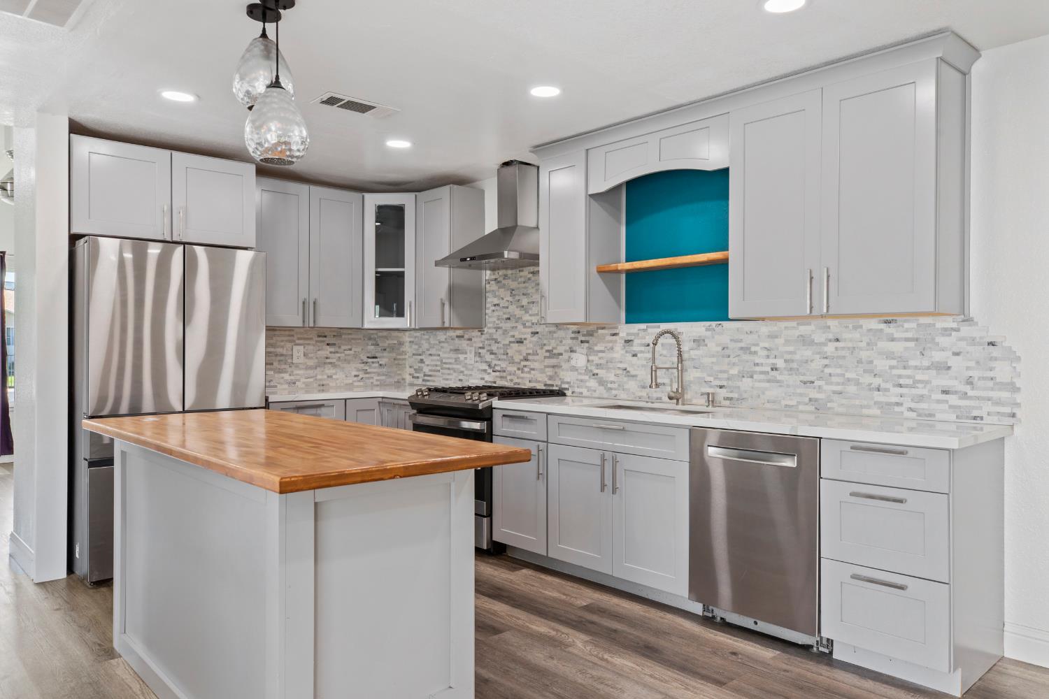 4005 Goldust Drive Modesto, CA 95355 - Photo 10 of 36 a kitchen that has a sink stainless steel appliances a refrigerator and a counter top space