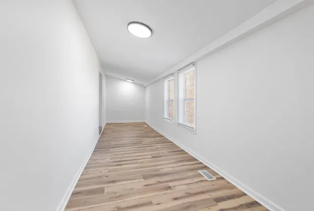 a view of a hallway with wooden floor