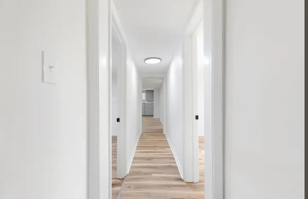 a view of a hallway with wooden floor