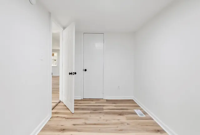 a view of empty room with wooden floor
