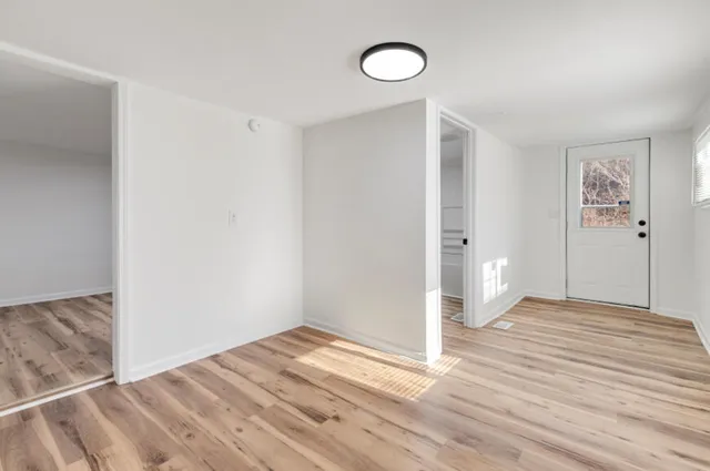 a view of empty room with wooden floor