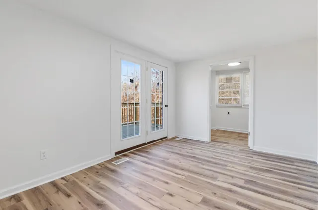 a view of empty room with wooden floor