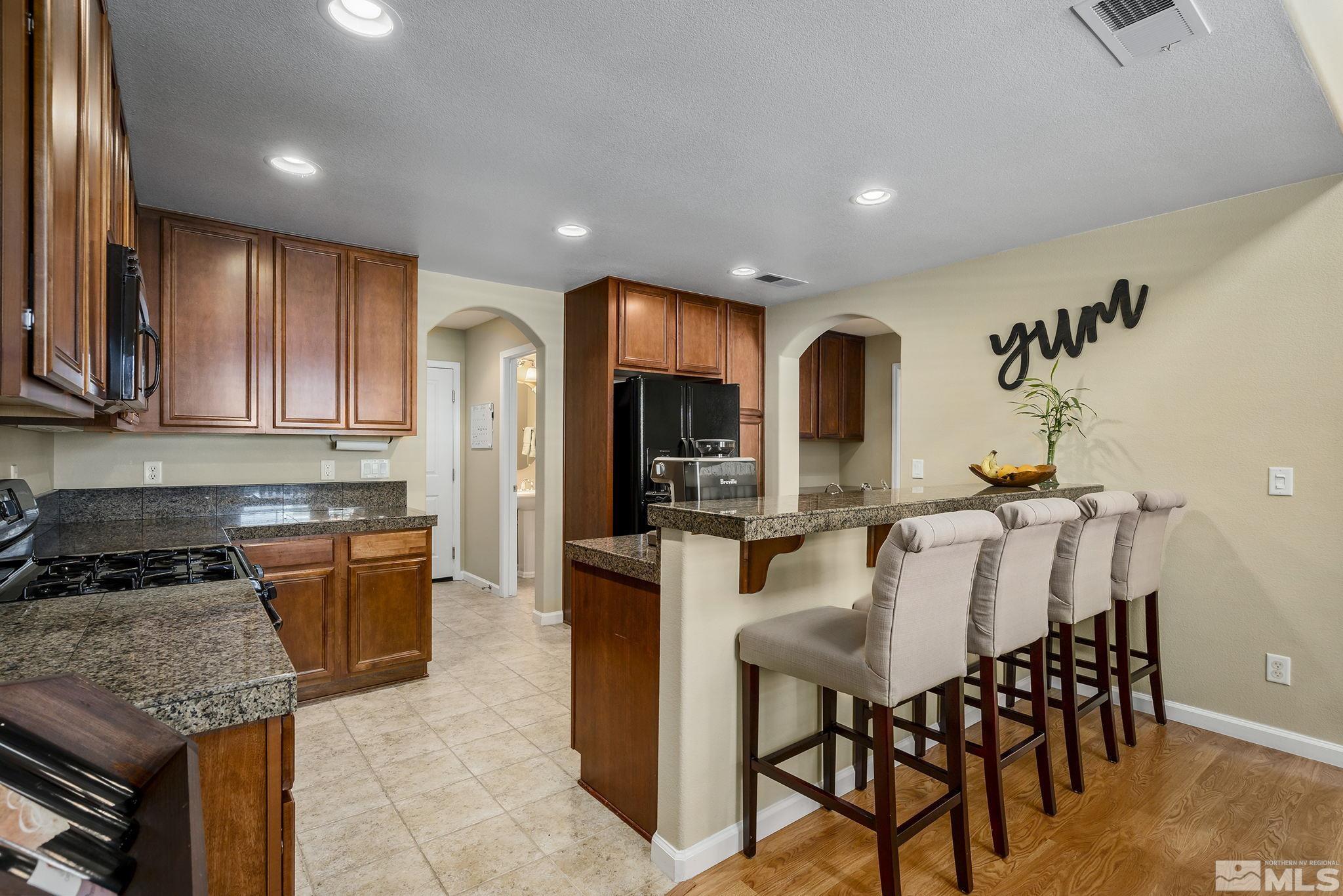 1618 Spring Hill Drive Reno, NV 89523 - Photo 6 of 25 a kitchen with stainless steel appliances granite countertop wooden cabinets a stove top oven a sink and dishwasher