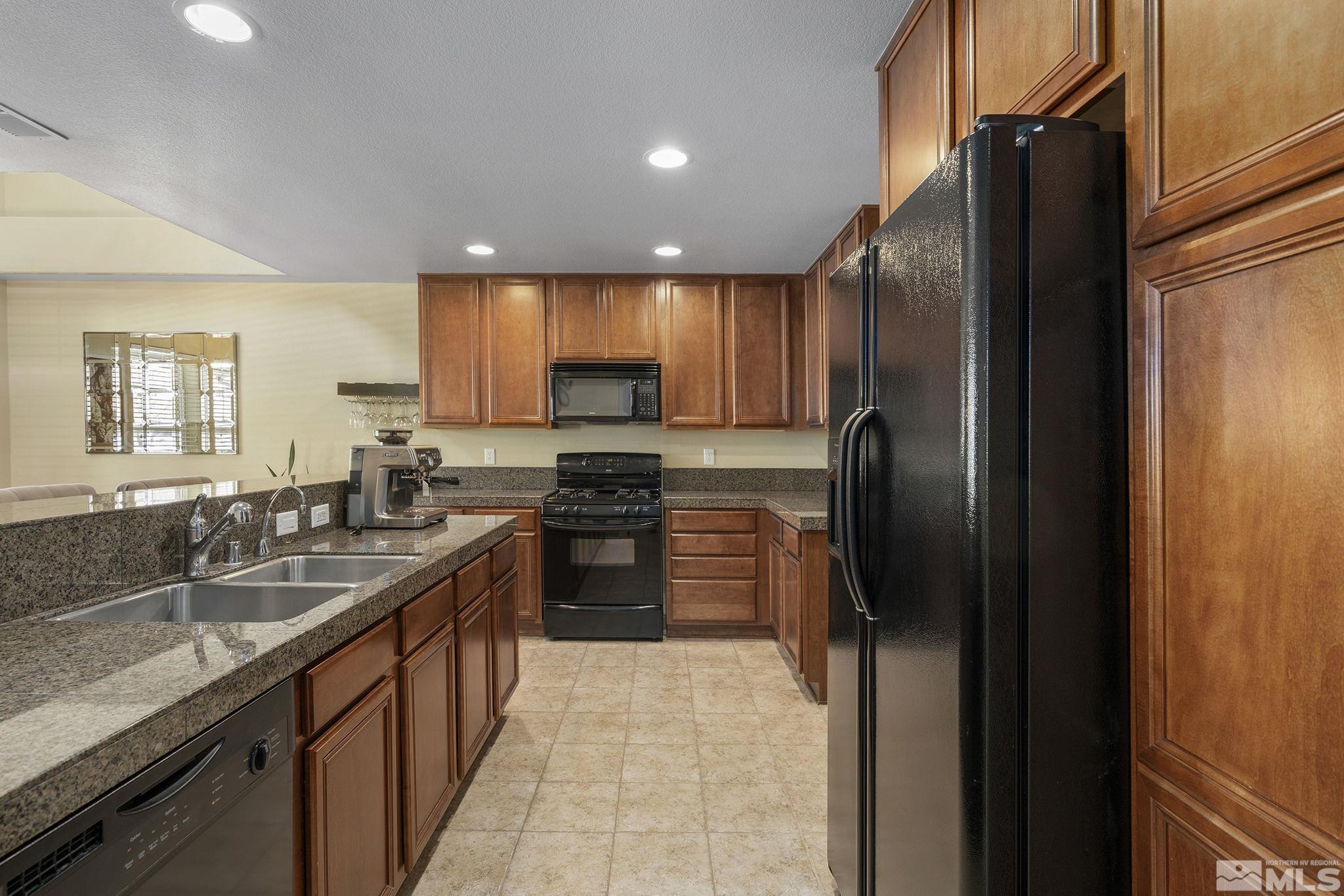 1618 Spring Hill Drive Reno, NV 89523 - Photo 8 of 25 a kitchen with stainless steel appliances granite countertop a refrigerator a sink a stove and a sink