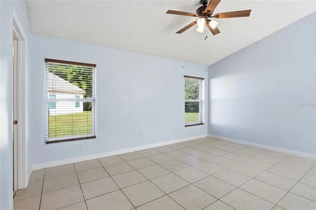 an empty room with windows and fan