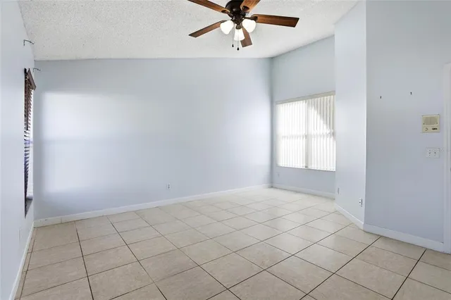 an empty room with fan and windows