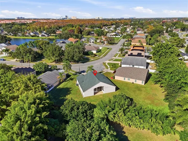 an aerial view of residential houses with outdoor space and trees