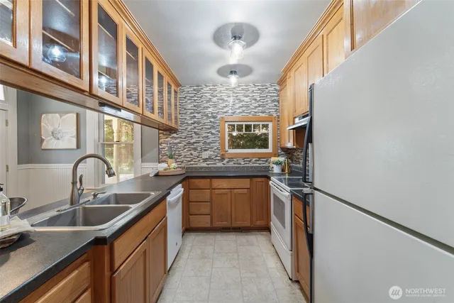 a kitchen with stainless steel appliances granite countertop a sink and a refrigerator