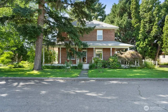 a front view of a house with a yard and trees