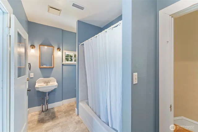 a view of a hallway with bathroom and a mirror