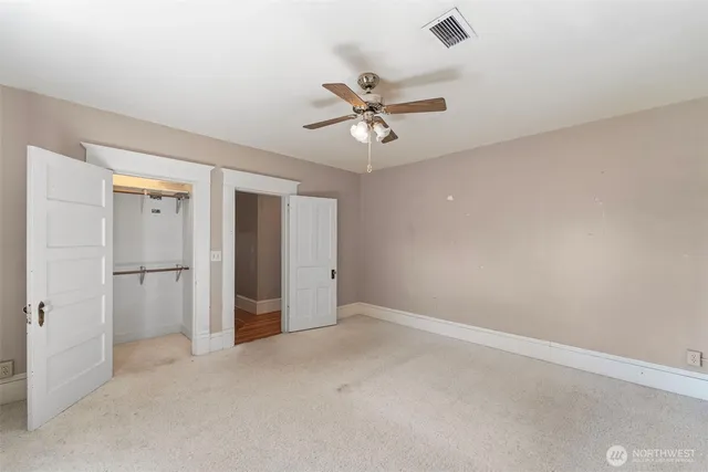 an empty room with closet and windows
