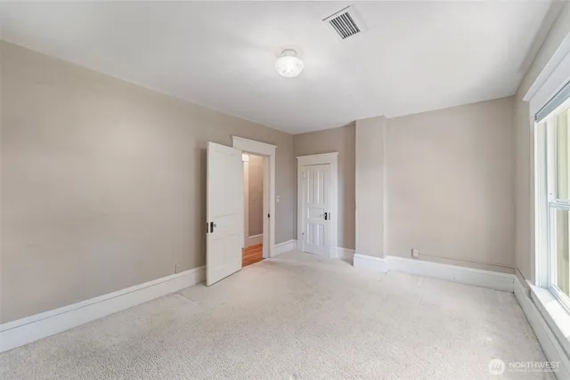 an empty room with windows and closet