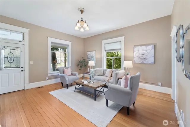 a living room with furniture and a wooden floor
