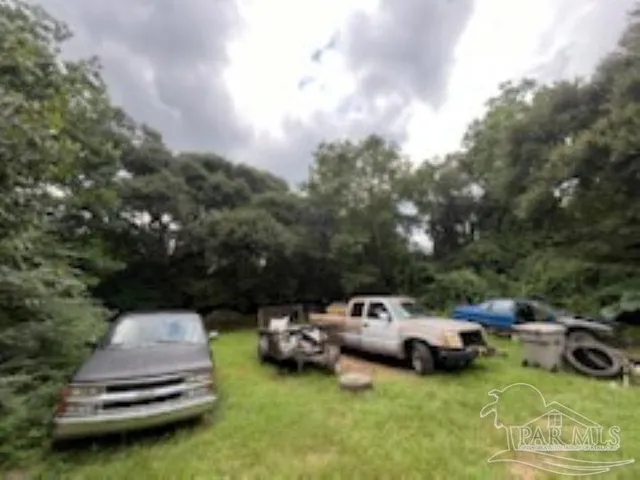 a view of a garden with lawn chairs and couches