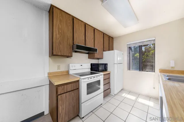 a kitchen with a stove top oven cabinets and a refrigerator