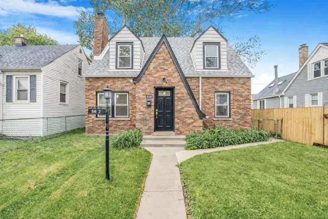 an empty room with wooden floor fireplace and windows