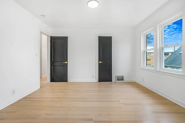 a view of an empty room with window and closet area