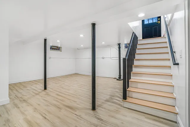 a view of a hallway with wooden floor and staircase