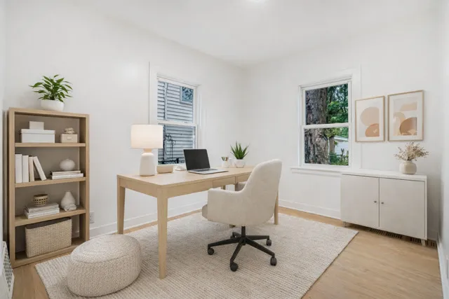 a view of a workspace with furniture and a window