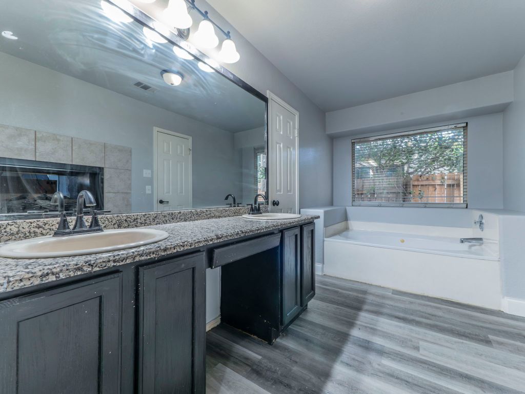 924 Satellite View Round Rock, TX 78665 - Photo 11 of 30 Master Bathroom with a bath, double vanity, and grey lvp finished floors