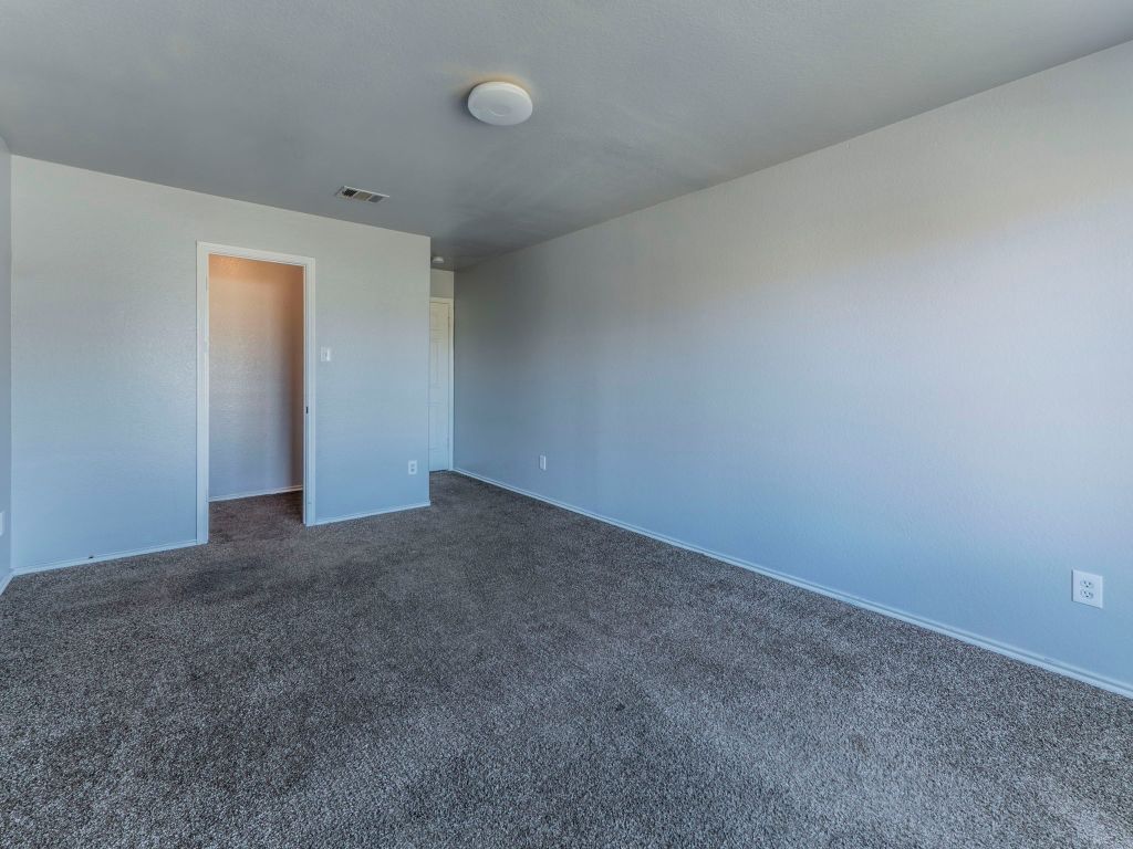 924 Satellite View Round Rock, TX 78665 - Photo 22 of 30 Unfurnished bedroom featuring dark colored carpet and baseboards