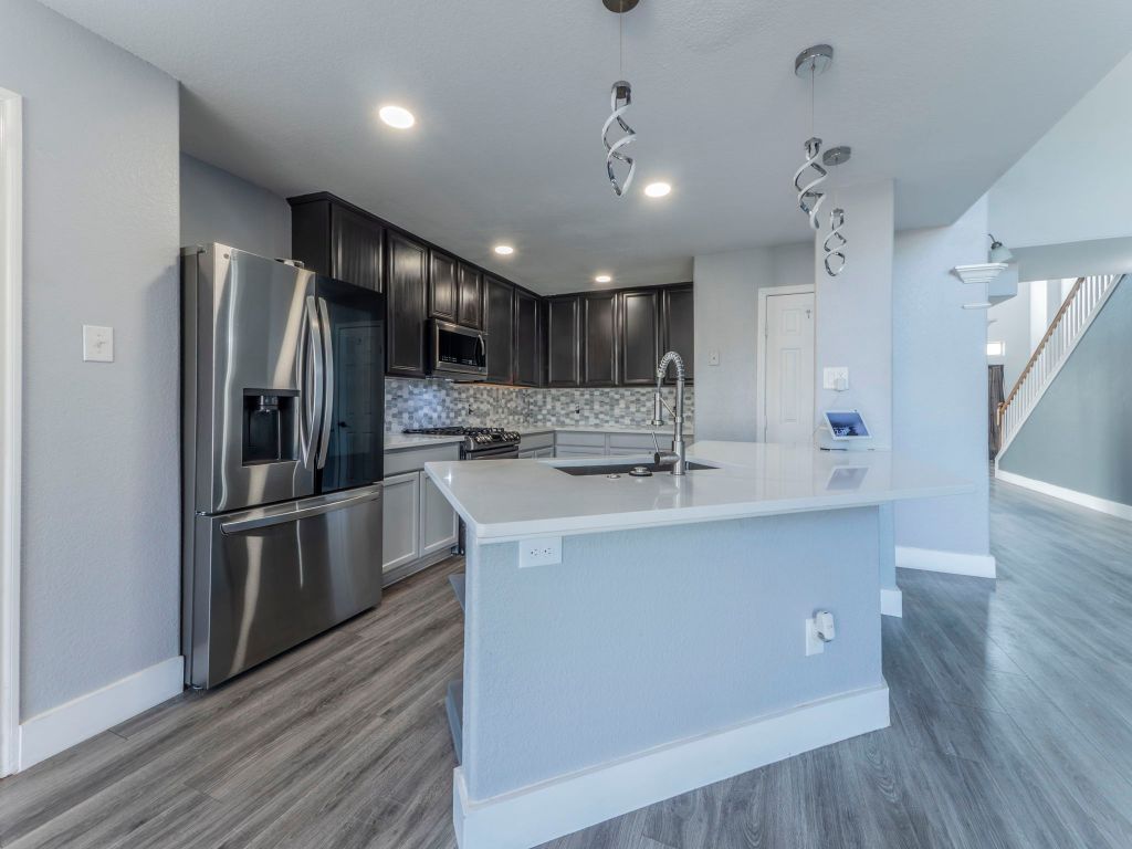 924 Satellite View Round Rock, TX 78665 - Photo 6 of 30 Kitchen with appliances with stainless steel finishes, backsplash, a center island with sink, pendant lighting, and dark wood-type flooring