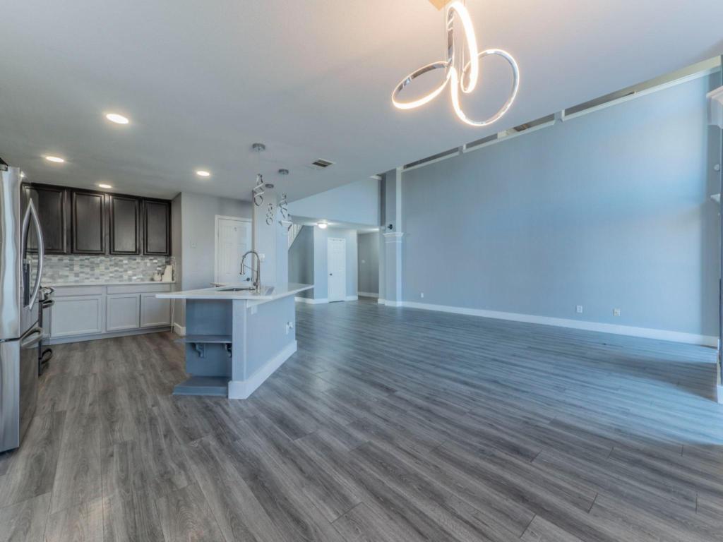 924 Satellite View Round Rock, TX 78665 - Photo 9 of 30 Kitchen with freestanding refrigerator, decorative backsplash, an island with sink, dark wood-style flooring, and recessed lighting