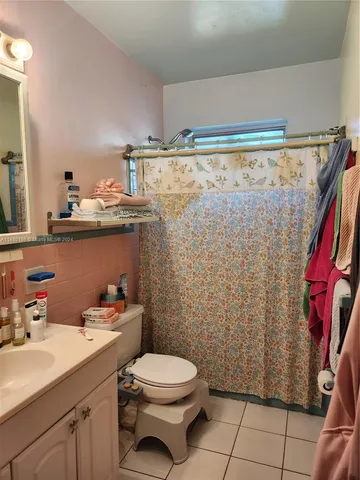 a bathroom with a sink a toilet and shower curtain