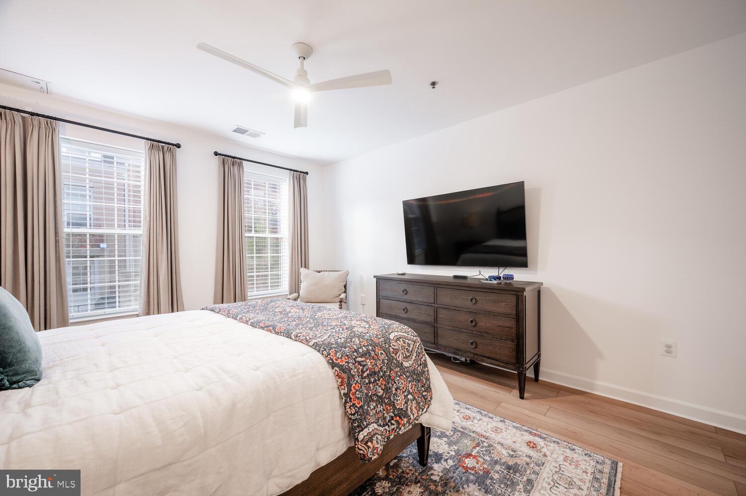 10328 Sager Avenue, Unit 217 Fairfax, VA 22030 - Photo 18 of 42 a bedroom with a bed and a flat screen tv