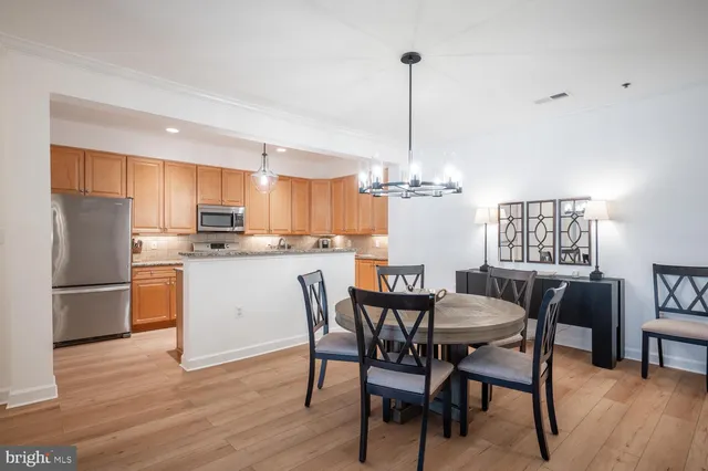 a view of kitchen with refrigerator a dining table and chairs