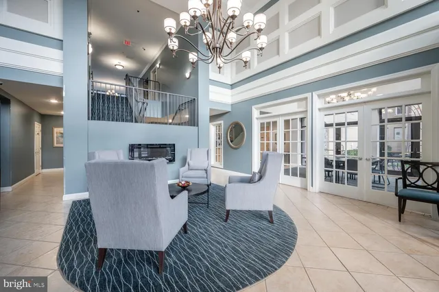 a living room with furniture a fireplace and a chandelier
