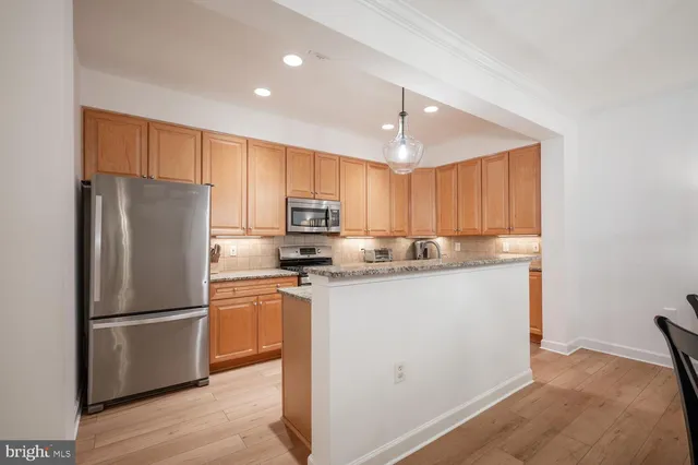 a kitchen with granite countertop a refrigerator stove and microwave