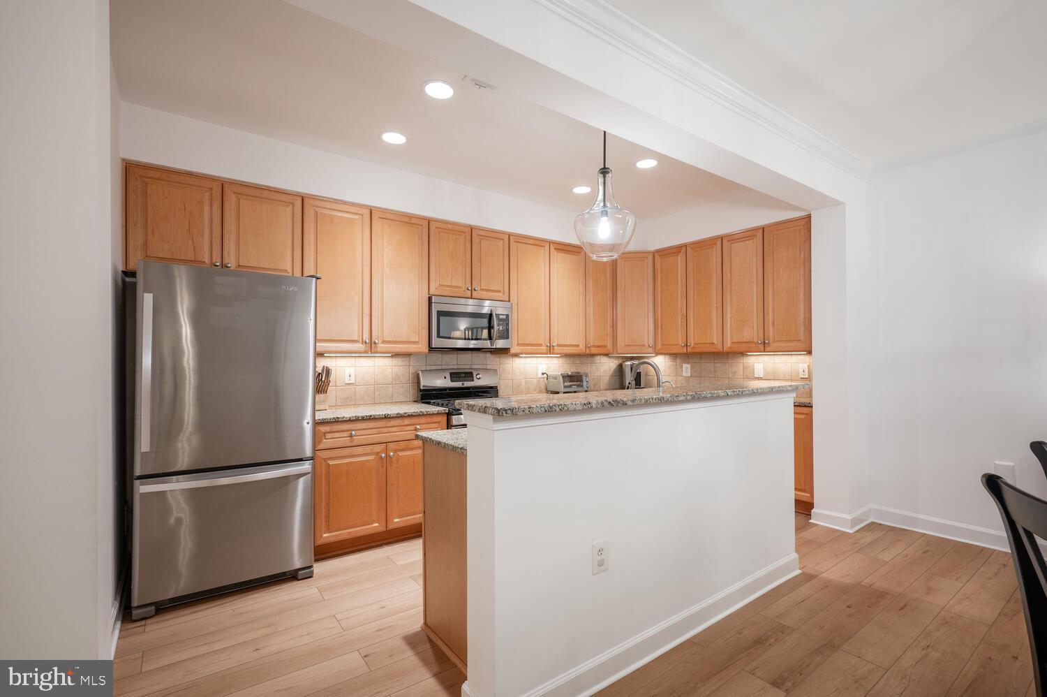 10328 Sager Avenue, Unit 217 Fairfax, VA 22030 - Photo 4 of 42 a kitchen with granite countertop a refrigerator stove and microwave