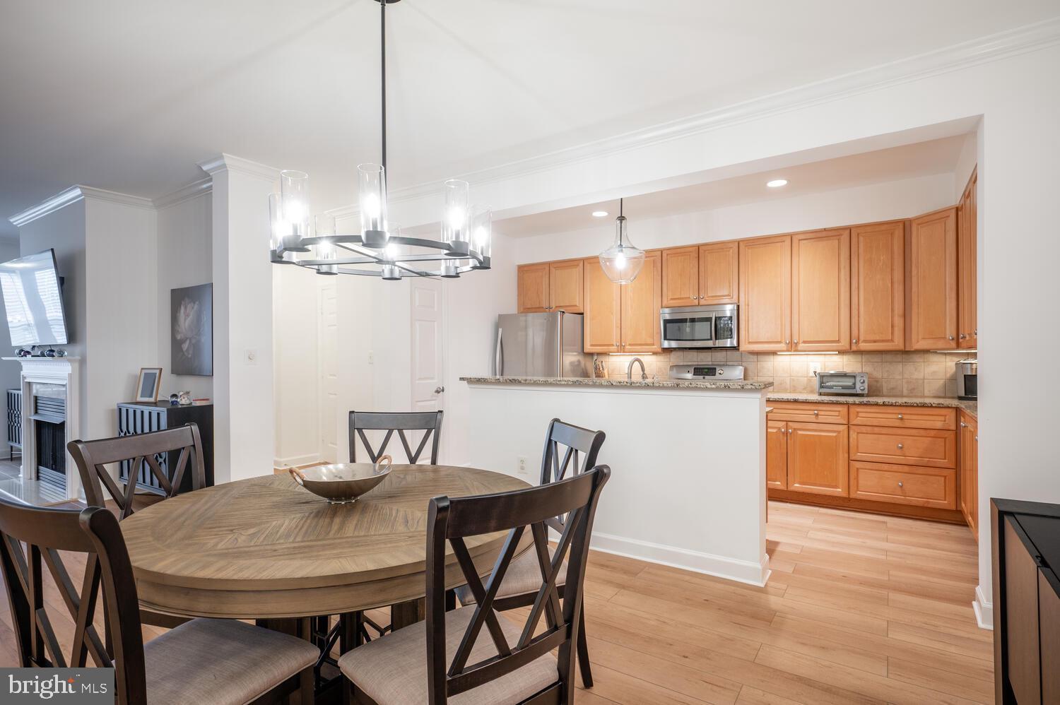 10328 Sager Avenue, Unit 217 Fairfax, VA 22030 - Photo 5 of 42 a kitchen with stainless steel appliances kitchen island granite countertop a dining table chairs and a refrigerator