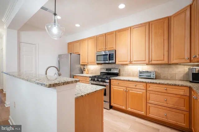 a kitchen with stainless steel appliances granite countertop a stove a sink dishwasher and a microwave