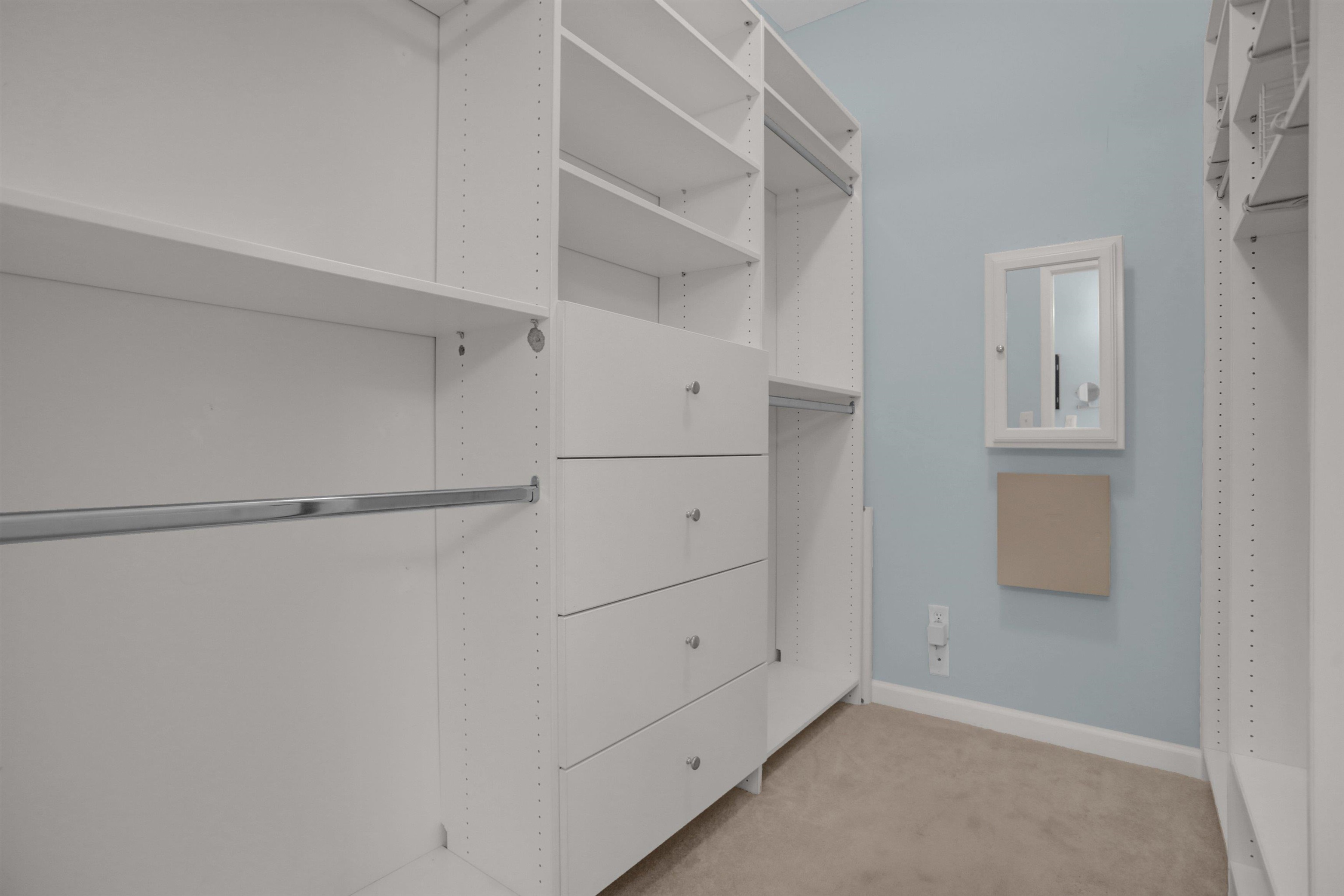 34 Peyton Ridge Drive, Unit 21 Collierville, TN 38017 - Photo 28 of 37 Custom closet system featuring white shelving, multiple hanging rods, and integrated drawer storage with brushed nickel pulls