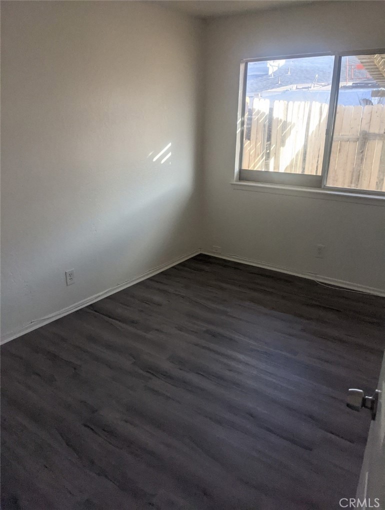 15927 Sago Road Apple Valley, CA 92307 - Photo 1 of 1 a view of an empty room with wooden floor and a window
