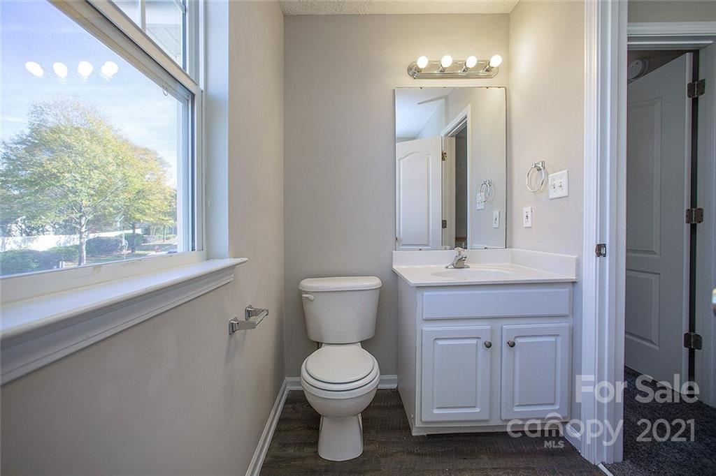 881 Raindrops Road Gastonia, NC 28054 - Photo 16 of 25 a bathroom with a toilet a sink a mirror and a window
