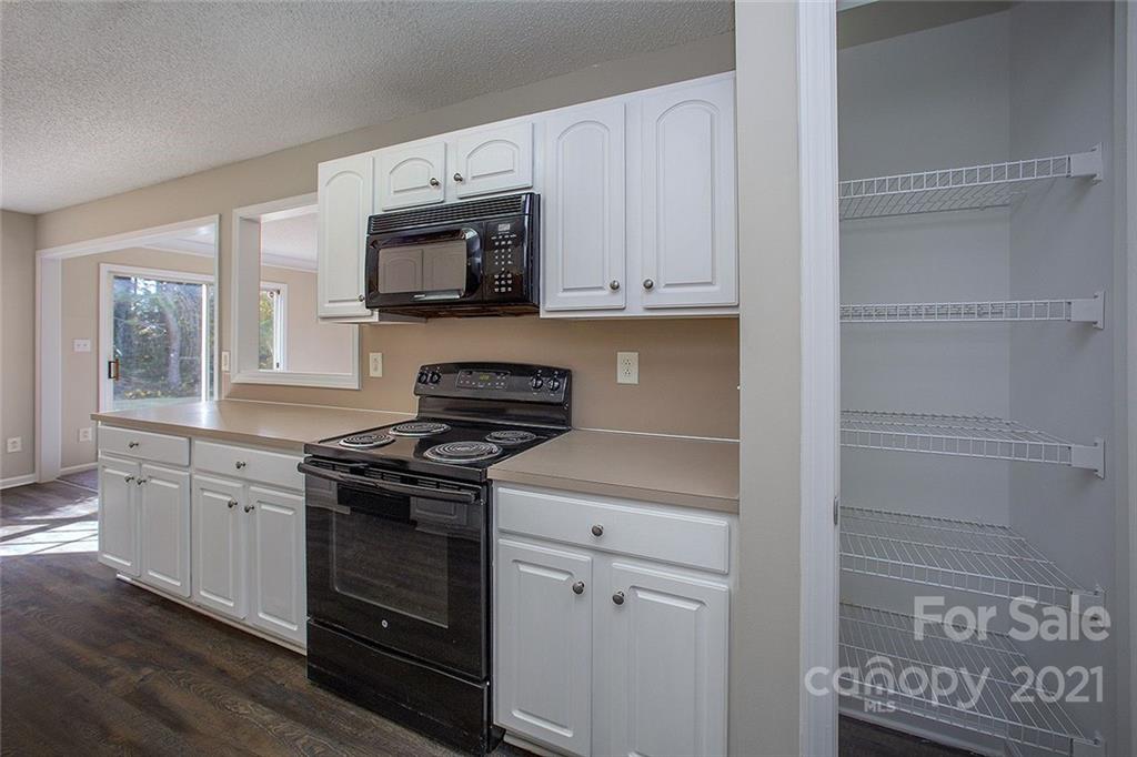 881 Raindrops Road Gastonia, NC 28054 - Photo 4 of 25 a kitchen with stainless steel appliances granite countertop white cabinets and a stove top oven