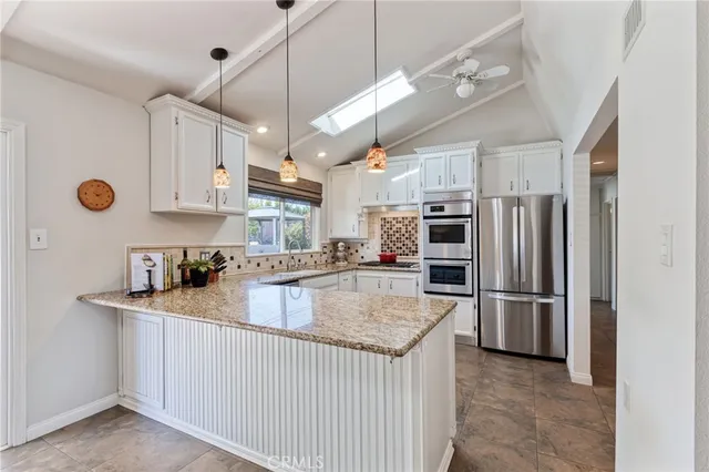 a kitchen with granite countertop a sink stainless steel appliances and cabinets