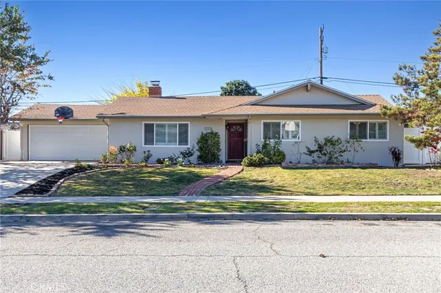 a view of a house with a small yard and potted plants